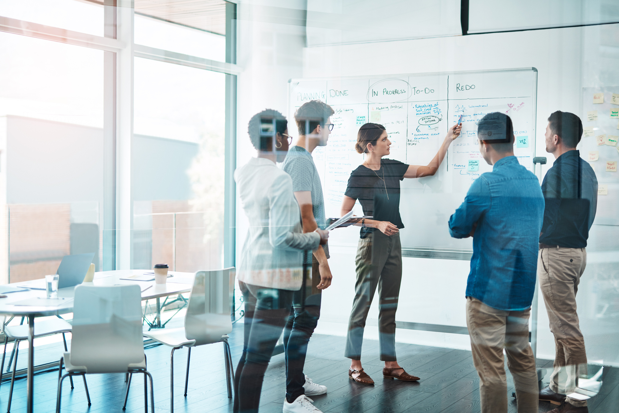 Mitarbeiter:innen Meeting mit Hilfe eines Whiteboards.